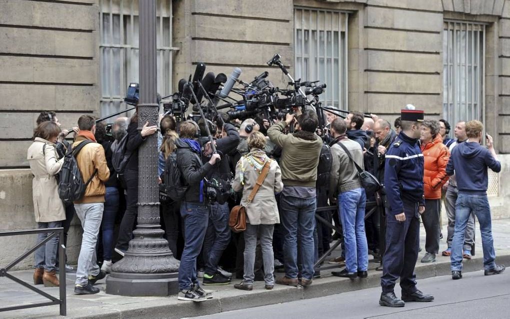 Franse journalisten klitten dinsdag samen bij het hoofdkantoor van de UMP, nadat bekend werd dat er een mogeijk financieel schandaal is. beeld AFP