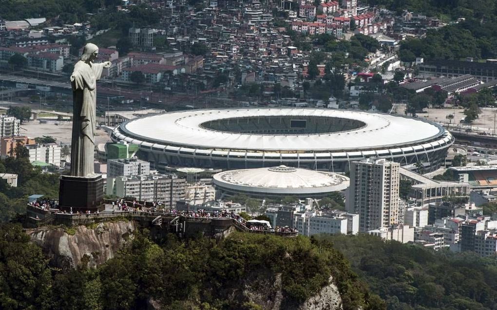 In Rio de Janeiro, een van de speelsteden van het WK, torent het wereldberoemde standbeeld van Christus de Verlosser boven het voetbalstadion uit. beeld AFP