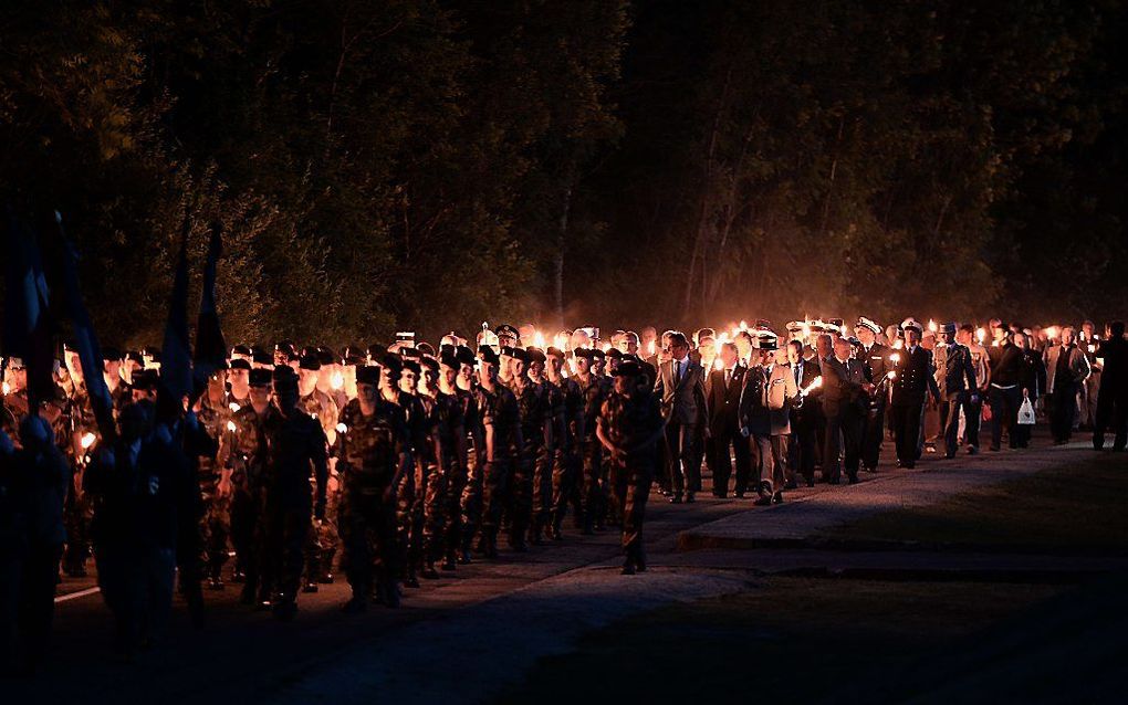 Soldaten lopen in een fakkeloptocht de Douaumont in het oosten van Frankrijk, tijdens het jaarlijkse evenement Vierdaagse van Verdun. Een nachtelijke parade van veteranen die de de strijd bij Verdun herdenken. beeld EPA