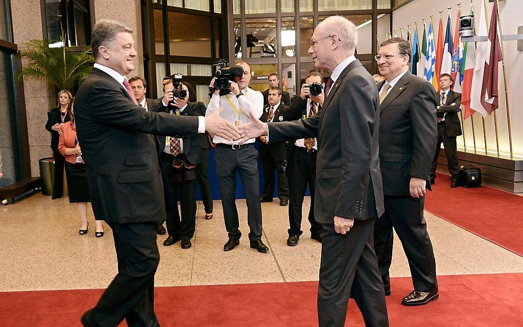 De Oekraïense president Porosjenko (L) wordt in Brussel verwelkomd door Commissievoorzitter Barroso (R) en Van Rompuy, de voorzitter van de Europese Raad. beeld EPA