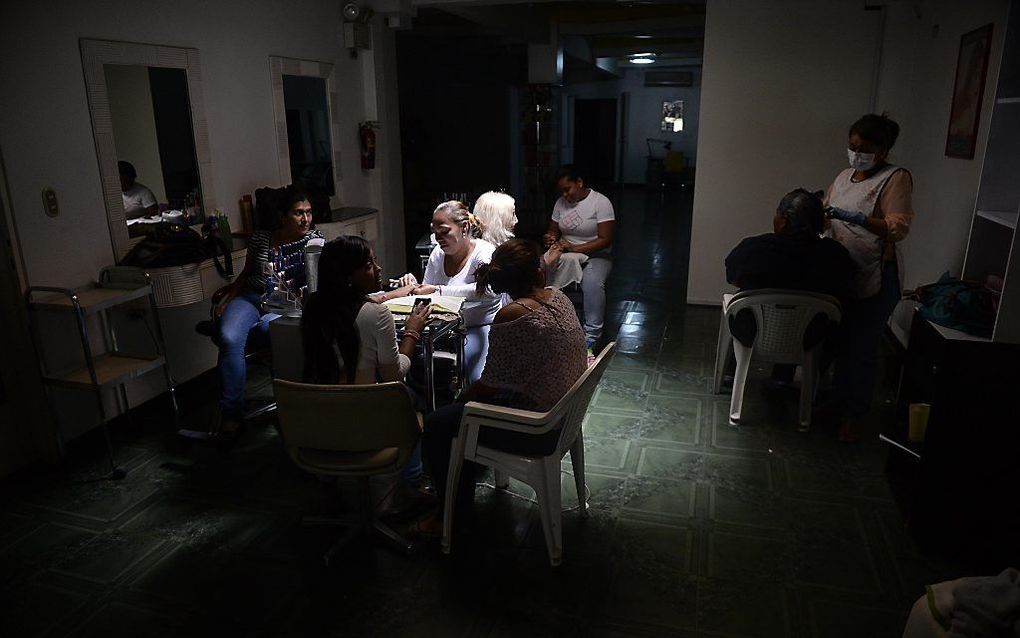 Een kapsalon in Caracas, tijdens de stroomstoring. Beeld AFP