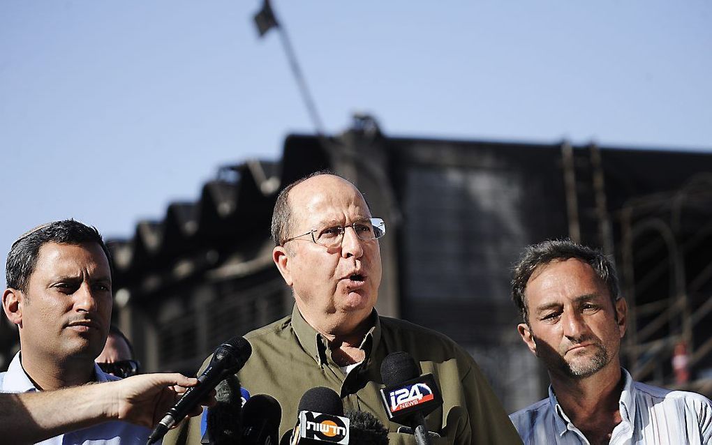 De Israëlische minister van Defensie Moshe Yaalon bij een door Palestijnse raketten beschadigde fabriek in Sderot. Beeld AFP