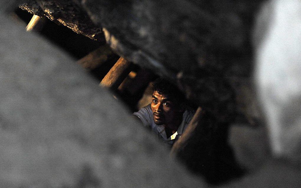 Een man daalt af in de ingestorte mijn in Honduras. Beeld AFP