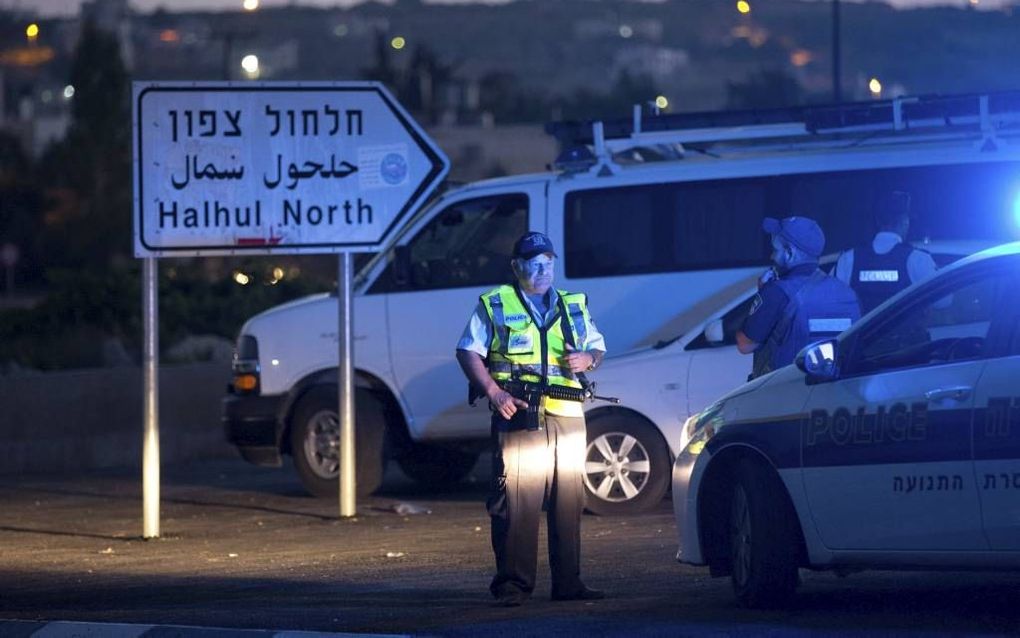 HALHUL. Een Israëlische politieman hield de wacht in Halhul, een dorpje in de buurt van Hebron. Daar werden op 30 juni de lichamen van de drie vermoorde Israëlische tieners gevonden. beeld AFP