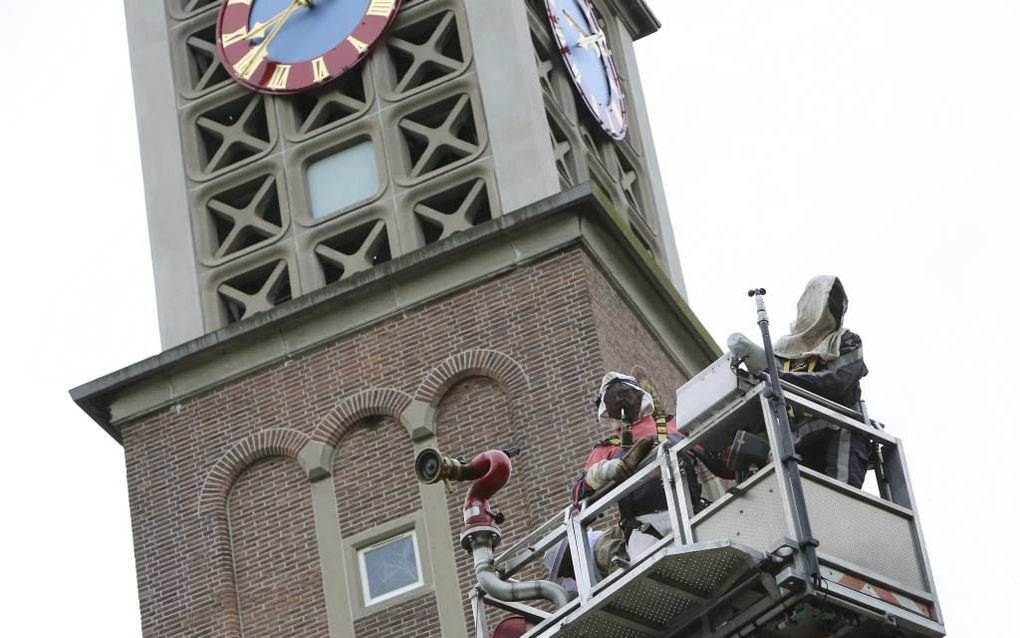 OCHTEN. Het verwijderen van de bijenzwerm gisteravond uit de toren van de hervormde kerk van Ochten was „een zware bevalling”, meldde imker Zomerdijk toen hij na een klein halfuur weer beneden stond. beeld Vidiphoto