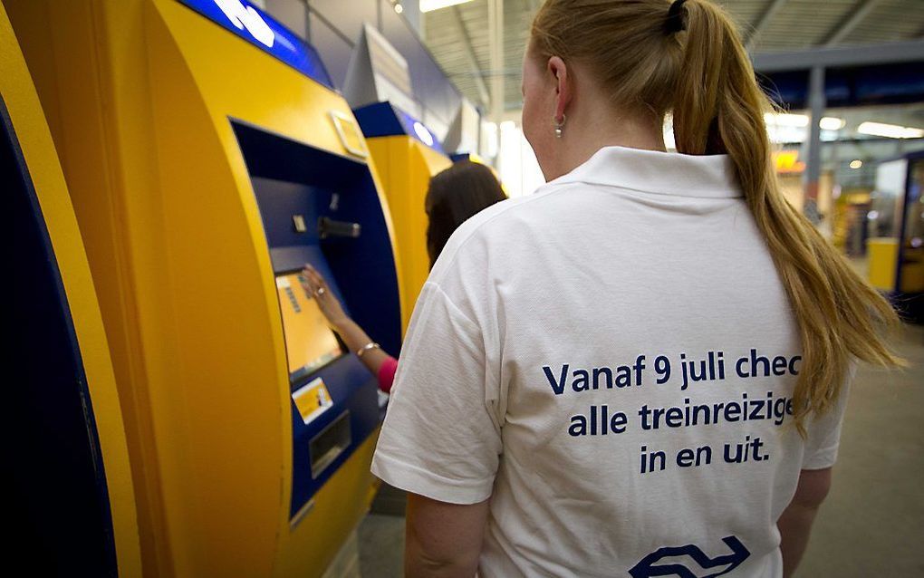 Medewerkers van NS assisteren bij kaartautomaten. beeld ANP