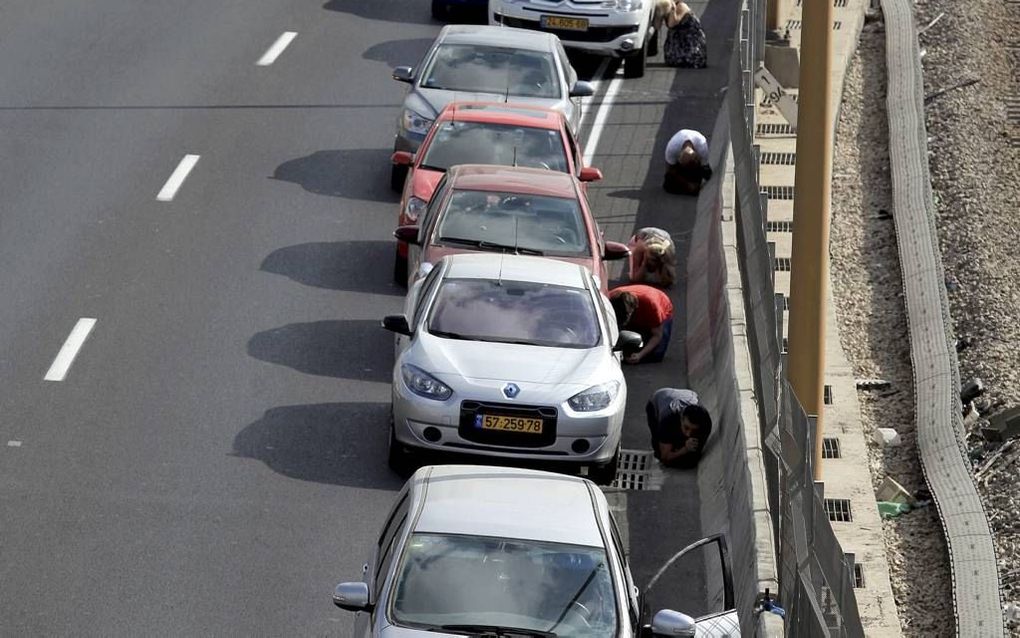 TEL AVIV. Israëlische automobilisten zochten gisteren dekking op een snelweg in de buurt van Tel Aviv, nadat het luchtalarm was afgegaan. Het antiraketsysteem Iron Dome heeft de meeste projectielen die op Tel Aviv werden afgevuurd uit de lucht geschoten. 