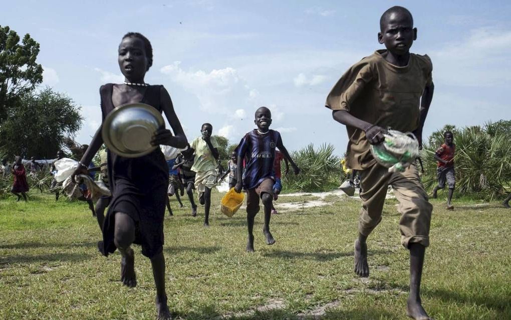 Kinderen zetten het op een rennen naar de plek van een voedseldropping vanuit de lucht in Leer, Zuid-Sudan, vorige week. Artsen zonder Grenzen hekelt in een kritisch rapport de trage hulpverlening in onder meer Zuid-Sudan.  beeld AFP