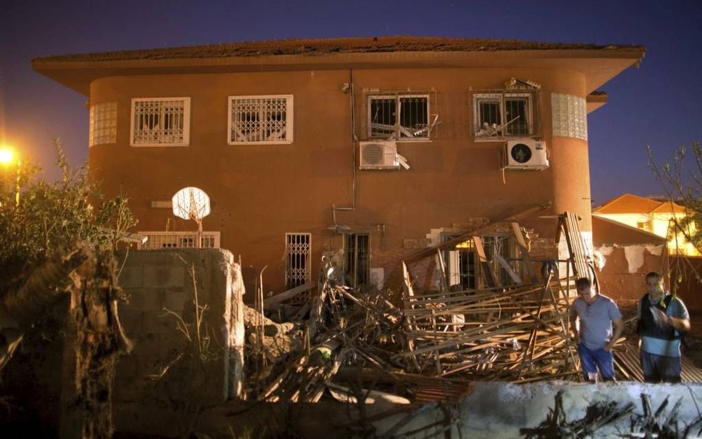 BE’ER SHEVA. Israëlische burgers inspecteerden gisteren de schade aan een woning in Be’er Sheva na een raketaanval door militanten vanuit de Gazastrook.  beeld AFP