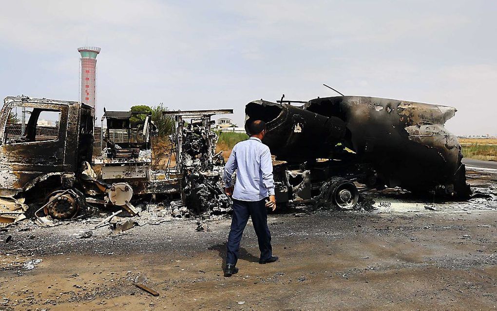 Uitgebrande auto's bij het vliegveld van Tripoli. Foto AFP