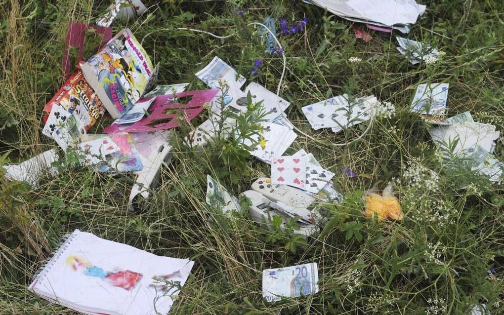 Bezaaid over de rampplek liggen de eigendommen van passagiers van de gecrashte Boeing 777 van Malaysia Airlines: een Donald Duck, een tekenboek. beeld AFP