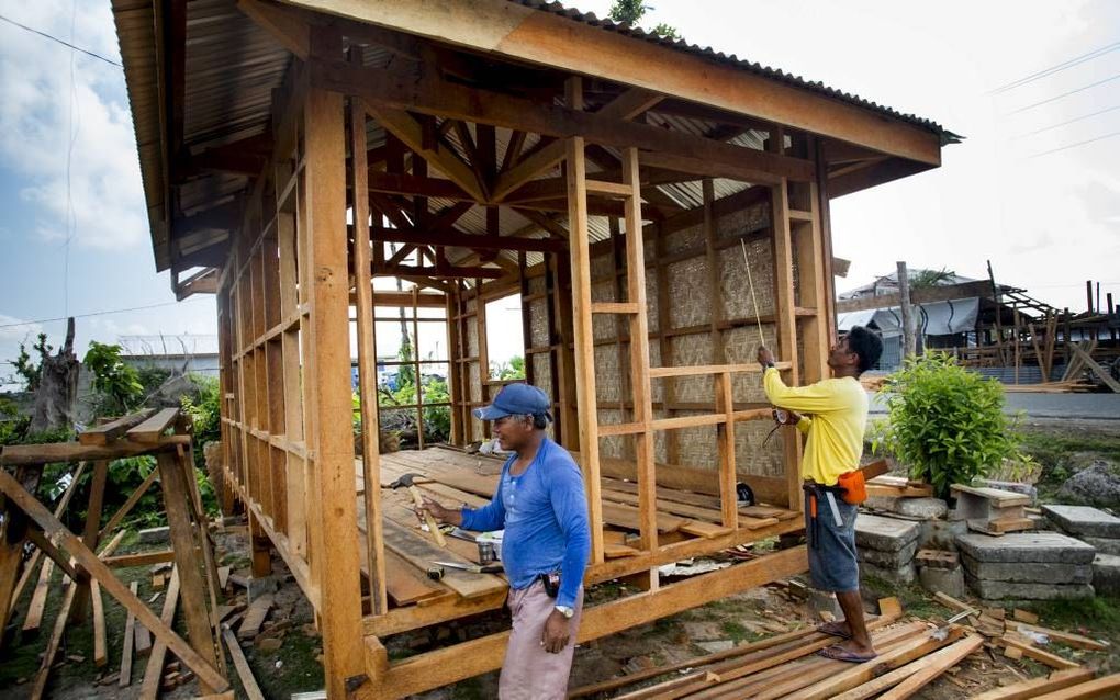 Filippijnse timmerlieden werken aan de wederopbouw in het gebied dat in november getroffen werd door de typhoon Haiyan. beeld ANP