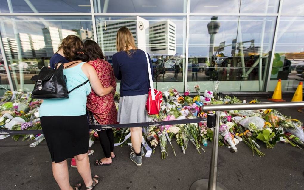 SCHIPHOL. Belangstellenden rouwen bij de bloemen bij vertrekhal 3 op luchthaven Schiphol. De plek is door de luchthaven ingericht als herdenkingsplek van de vliegramp in Oekraïne. beeld ANP