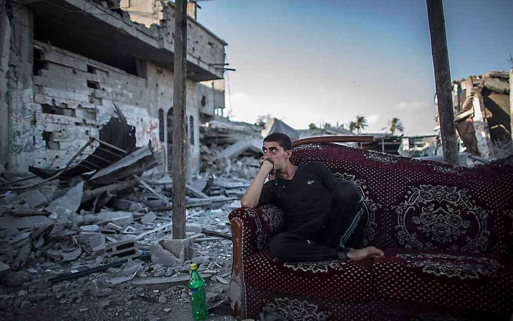 Een Palestijn tussen platgeschoten huizen in Gaza. Foto EPA