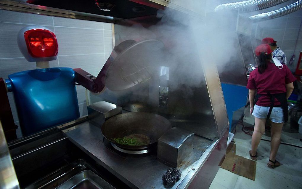 Een robot kookt groenten in een restaurant in de Chinese stad Kunshan. beeld AFP