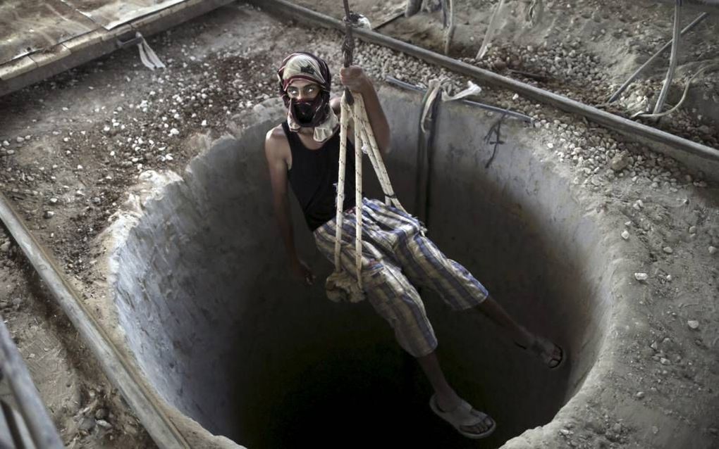 GAZA-STAD. Een Palestijn daalt af in een tunnel die hem naar Egypte brengt, waar hij smokkelwaar zal ophalen. beeld EPA