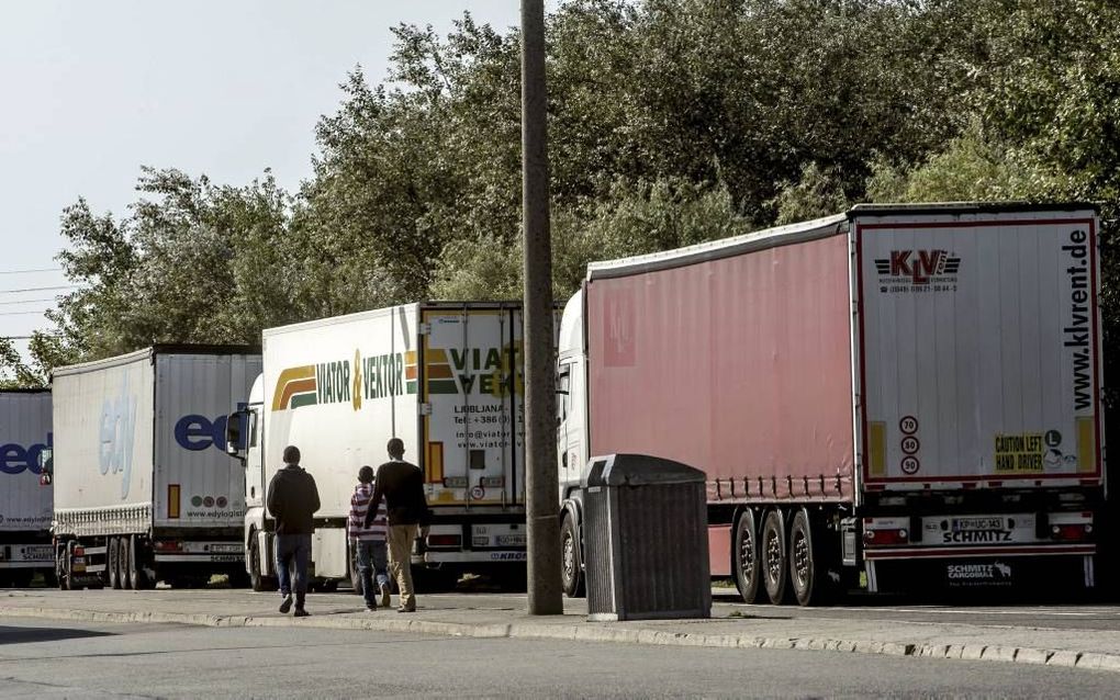 Migranten bij trucks in de Franse havenstad Calais. beeld AFP