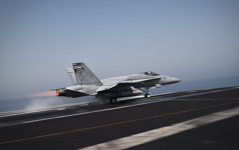 Een Amerikaanse F/A-18C Hornet stijgt op van vliegdekschip USS George H.W. Bush in de Perzische Golf. beeld AFP