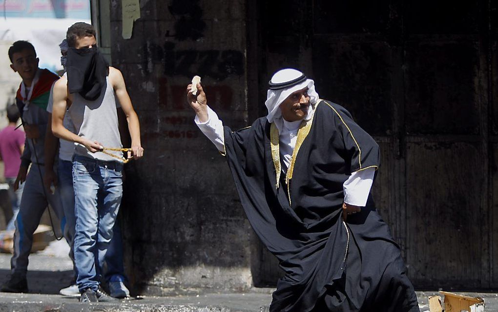 Palestijnen gooien stenen naar Israëlische veiligheidstroepen in Hebron. beeld EPA