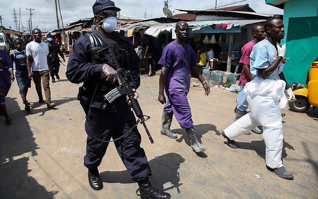 Militairen en medisch personeel in Monrovia, Liberia. Beeld EPA