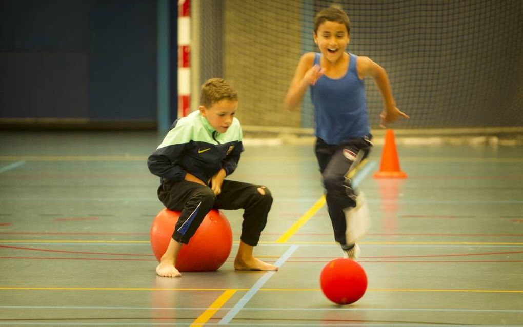 ROTTERDAM. Jongens vermaken zich met skippy- en voetbal in tijdens de sportdag van KerKado. beeld RD, Henk Visscher