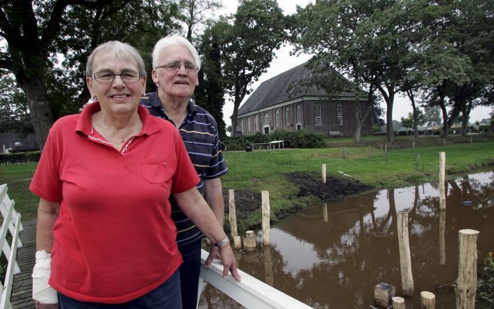 Zwaantje Gortemaker en haar man Roelof bij het beekje de Reest, waar  een replica van een zogeheten aalstal verrijst, een bouwwerk waarmee paling kan worden gevangen. beeld Eelco Kuiken