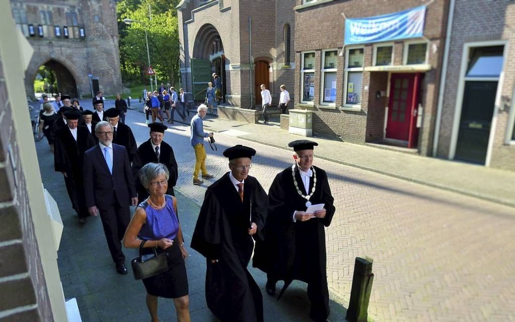 Prof. De Ruijter (m.), geflankeerd door zijn vrouw en rector prof. dr. M. te Velde, verlaat de Nieuwe Kerk. beeld RD