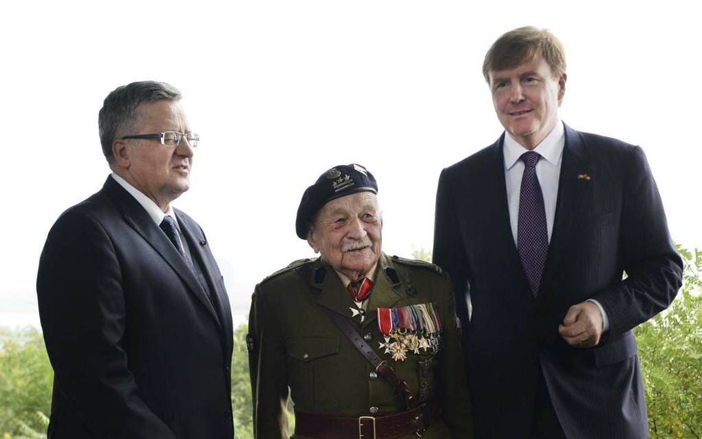 OOSTERBEEK. Voorafgaand aan de herdenking in Driel bezocht koning Willem-Alexander (r.) met een Poolse veteraan en diens president, Komorowski (l.), het droppingsgebied bij Oosterbeek. Beeld ANP