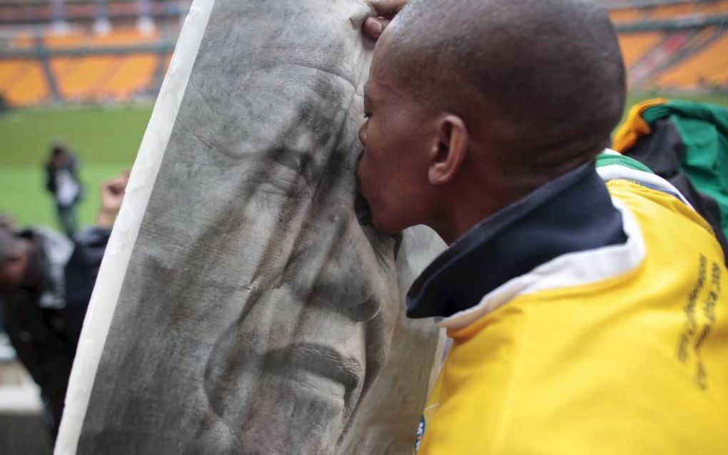 Een jongen kust een afbeelding van oud-president Mandela. beeld EPA