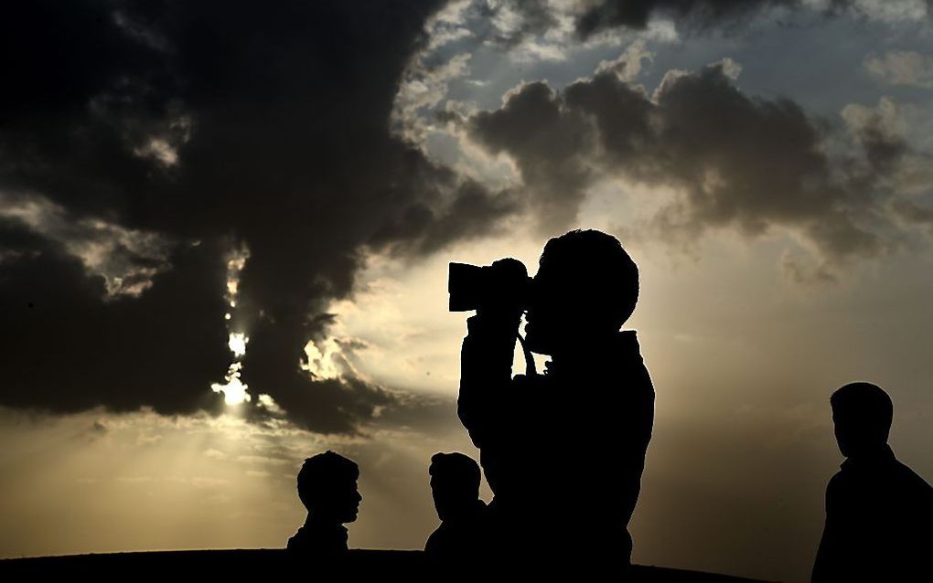 Koerden bekijken van afstand de strijd in Kobani. Beeld AFP