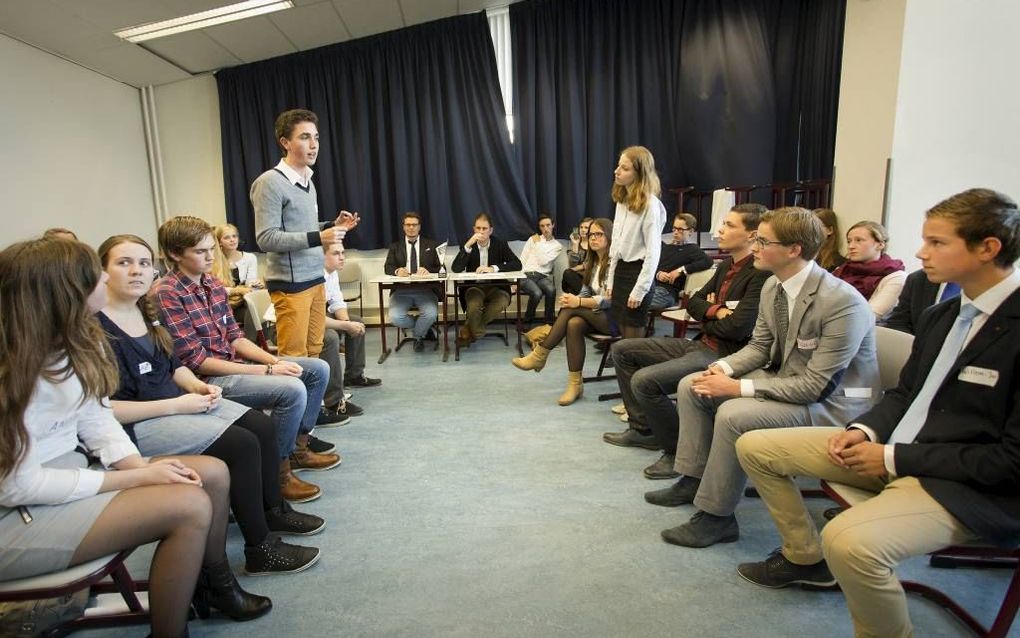 Teams van het Calvijn College (l.) en het Driestar College vrijdagmiddag tijdens de finale van RefDeb, de eerste debatwedstrijd tussen reformatorische middelbare scholen. beeld RD, Henk Visscher