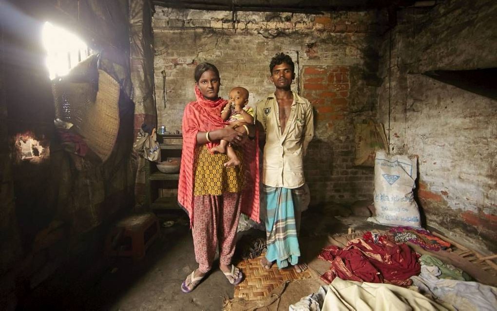 Sumi en Sukur poseren met hun vijf maanden oude kindje Sazal in hun schamele eenkamerhuisje in een van de krottenwijken van de stad Khulna, in het zuiden van Bangladesh. beeld Jaco Klamer