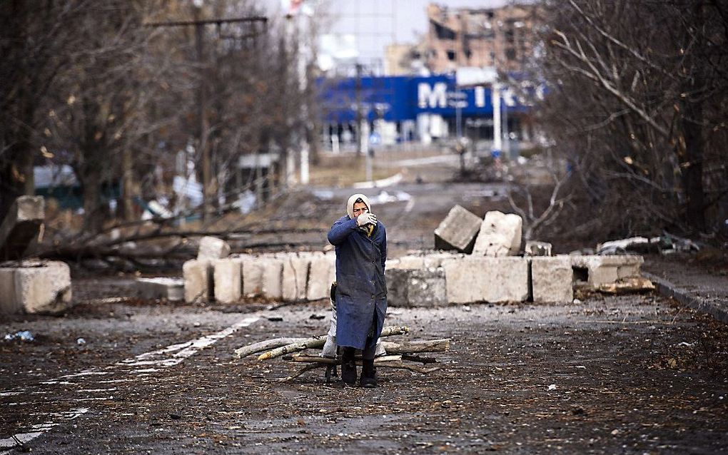 Een vrouw verzamelt brandhout in Donetsk. Beeld AFP