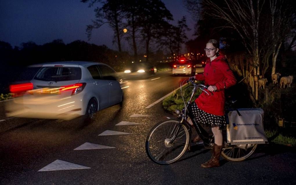 Ilse Biemond (14) uit Veenendaal wacht op de Heiveldweg in Veenendaal totdat ze de onveilige Klompersteeg kan oversteken om het RD te bezorgen. „Tot 2019 blijf ik op de N418 op mijn hoede.”  beeld Niek Stam