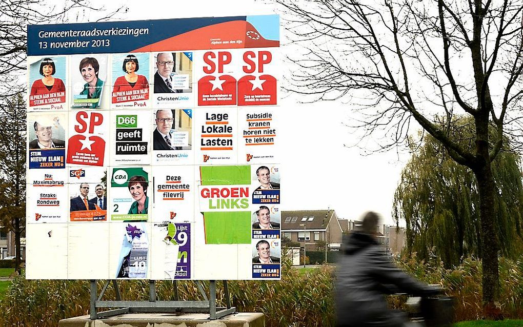 Verkiezingsaffiches op een bord in Alphen aan den Rijn, aan de vooravond van de stemming over de nieuwe fusiegemeente. Beeld ANP