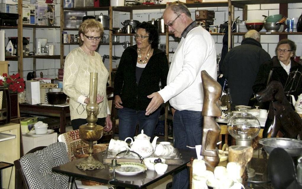 Vrijwilligers Corrie den Dekker-van Alten, Wil Korstanje en Jan Schipper (v.l.n.r.) werken in de kringloopwinkel. beeld Van Scheyen Fotografie