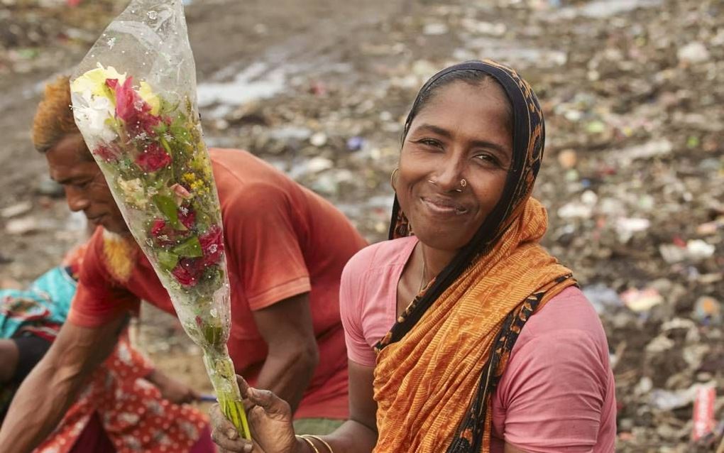 Asiah heeft op de vuilnisbelt van de stad Khulna zojuist een bos bloemen gevonden. beeld Jaco Klamer