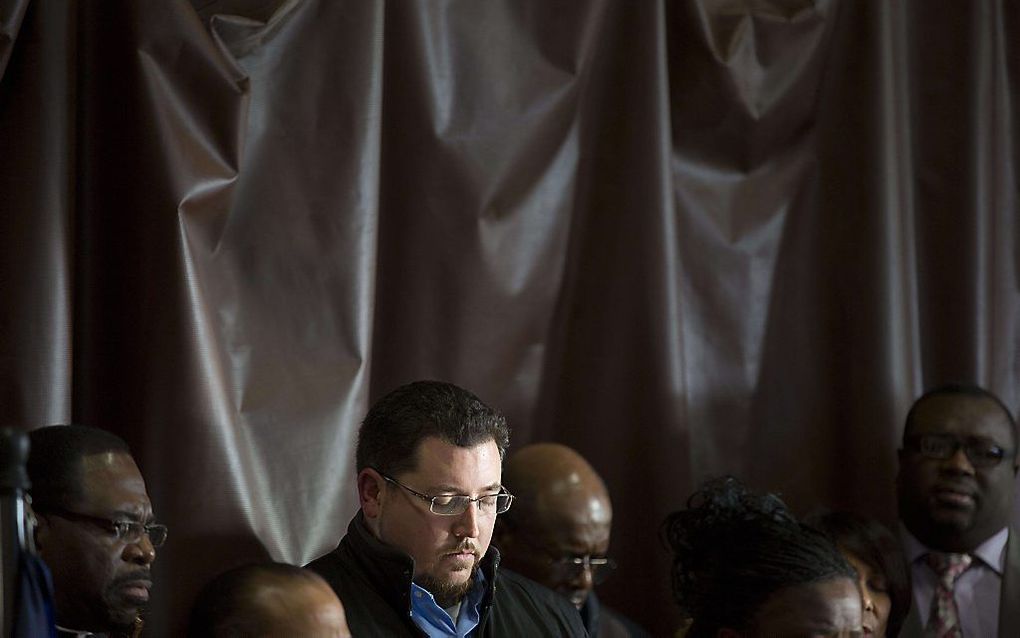 Gebed tijdens een persconferentie over de rellen in Ferguson.  beeld AFP