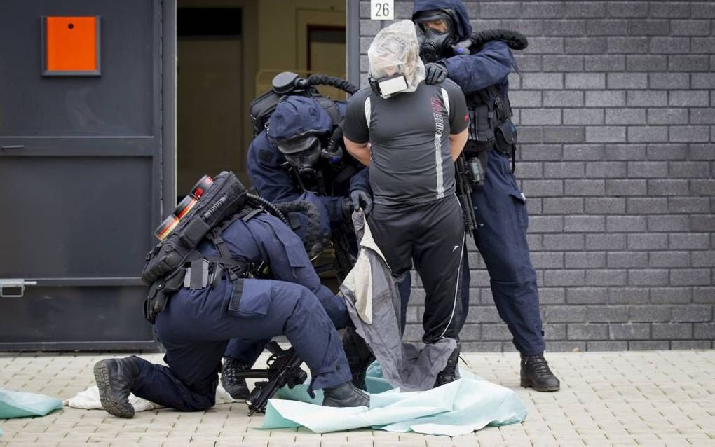 VUGHT. Met een plastic zak over het hoofd wordt een terreurverdachte afgevoerd. Een antiterreureenheid oefende gisteren bij de opening van het Nationaal Trainingscentrum CBRN in Vught voor chemische, biologische, radiologische of nucleaire rampen. beeld M