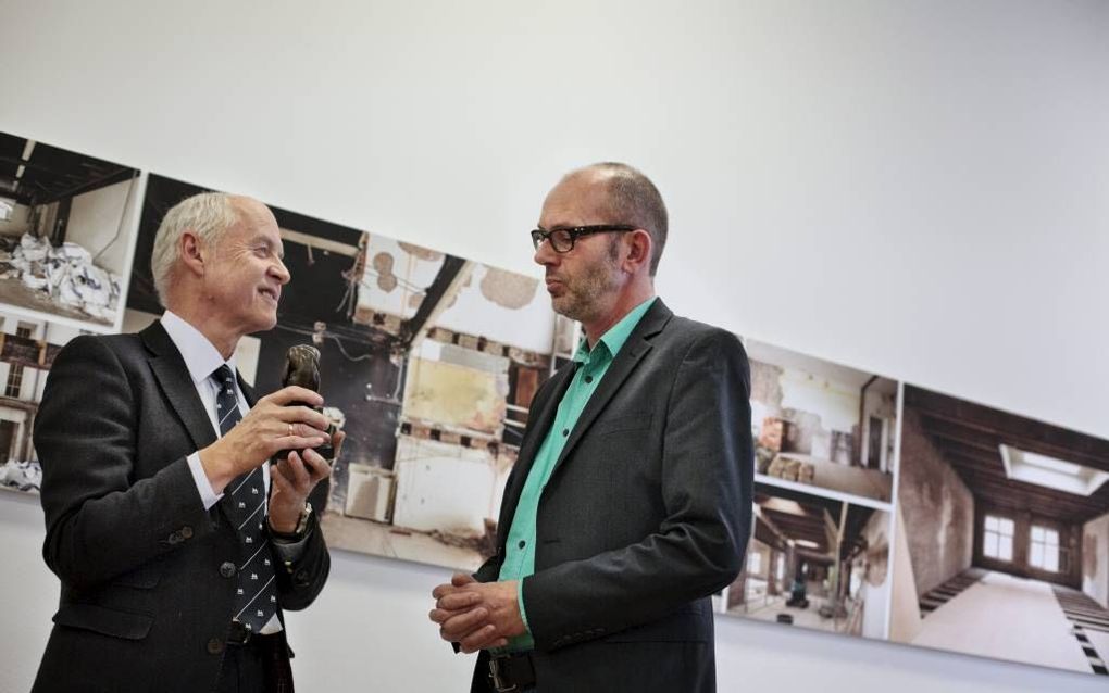 Schrijver Stevo Akkerman (r.) krijgt de eerste CLO Literaire Juryprijs uit handen van juryvoorzitter Hans Ester. Beeld Eran Oppenheimer