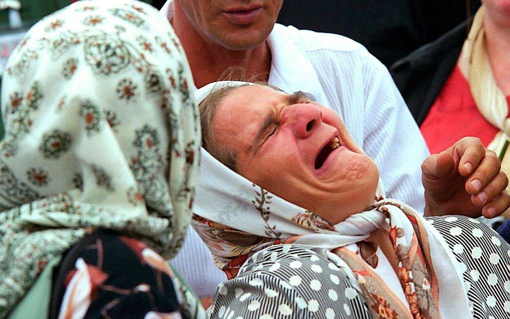 Een vrouw rouwt om overleden familieleden in Srebrenica. Beeld EPA