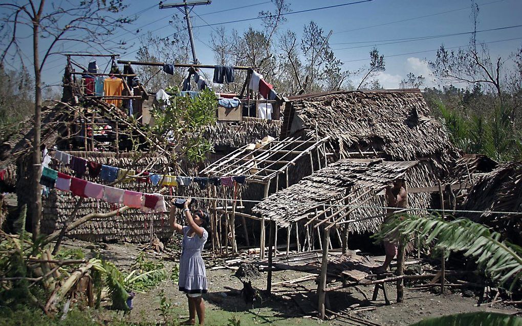 Een familie in Borongan pakt de draad van het leven weer op in hun verwoeste huis. beeld AFP