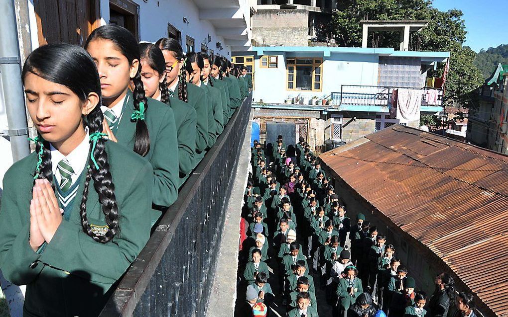 Indiase schoolkinderen rouwen om de slachtoffers van de aanval op een school in Pakistan door Talibanstrijders. beeld AFP