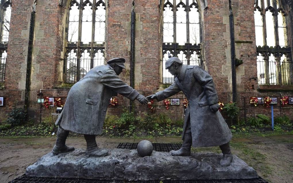 Een bronzen beeld in Liverpool herinnert aan de kerstbestenden. Een Engelse (links) en Duitse soldaat reiken elkaar de hand. beeld AFP