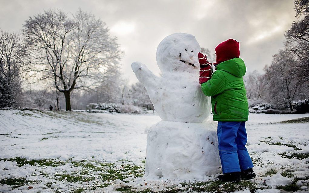 Een jongen maakt op tweede kerstdag een sneeuwpop in Berlijn. beeld EPA