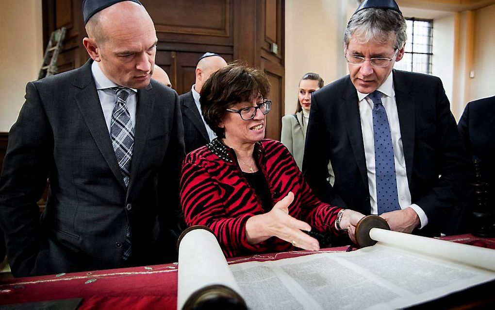 Rabbijn Marianne van Praag laat tijdens een rondleiding door de synagoge een Torah zien aan de leider van de ChristenUnie Arie Slob (R) en Tweede Kamerlid Gert-Jan Segers (L). Beeld ANP