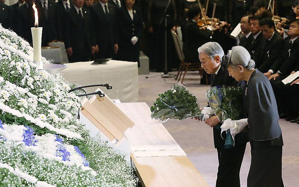 De Japanse keizer Akihito en zijn vrouw keizerin Michiko tijdens de herdenking van de aardbeving in Kobe. beeld AFP