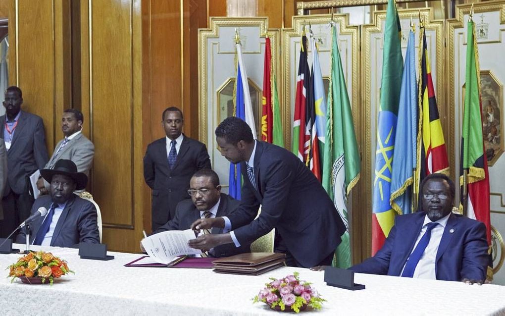 De Zuid-Sudanese president Salva Kiir (l.) en zijn rivaal Riek Machar (r.) tekenden gisteren een verdrag. Midden: de Ethiopische premier Hailemariam Desalegn. beeld AFP