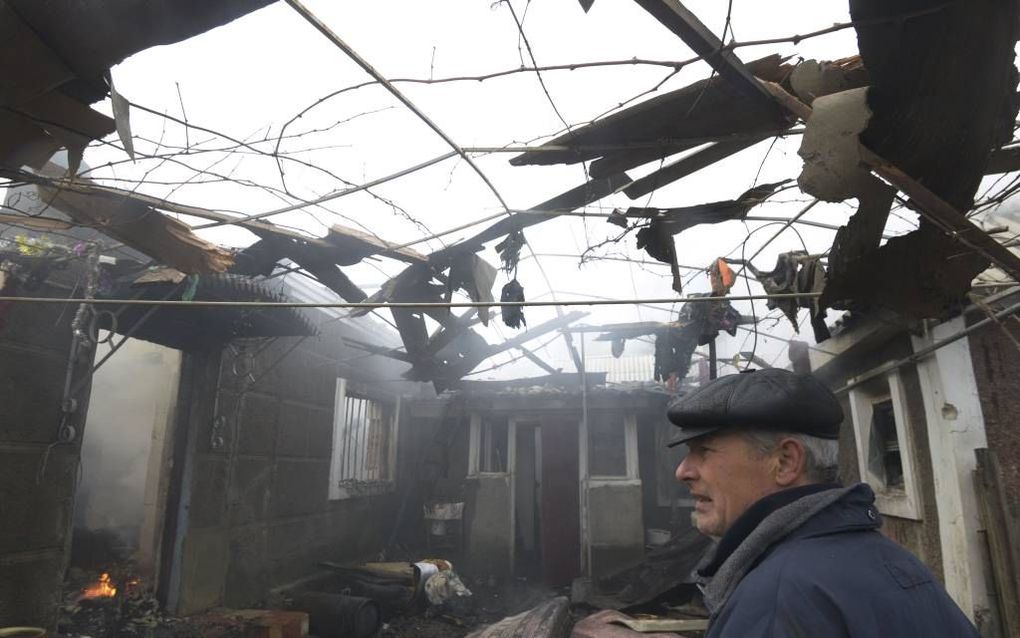 DONETSK. Een inwoner van Donetsk treurt over zijn woning die net door artillerievuur is verwoest. De Oost-Oekraïense stad en haar omgeving liggen al weken onder vuur nu de strijd tussen regeringsleger en separatisten weer helemaal is opgelaaid. beeld AFP