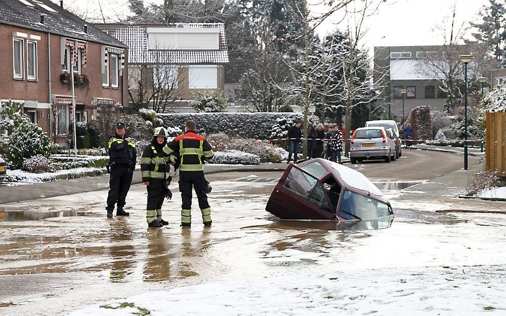 In de Brabantse plaats Sint-Oedenrode is donderdag een auto in een gat in de weg gezakt door een breuk in de waterleiding. De bestuurster kon haar auto op tijd verlaten, voordat het voertuig verder in het gat verdween. beeld ANP